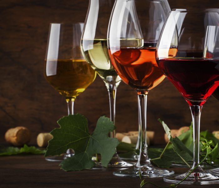 Wine set. Red, white and rose wine in assortment in wineglasses. Wine tasting, vintage wooden background, selective focus, copy space